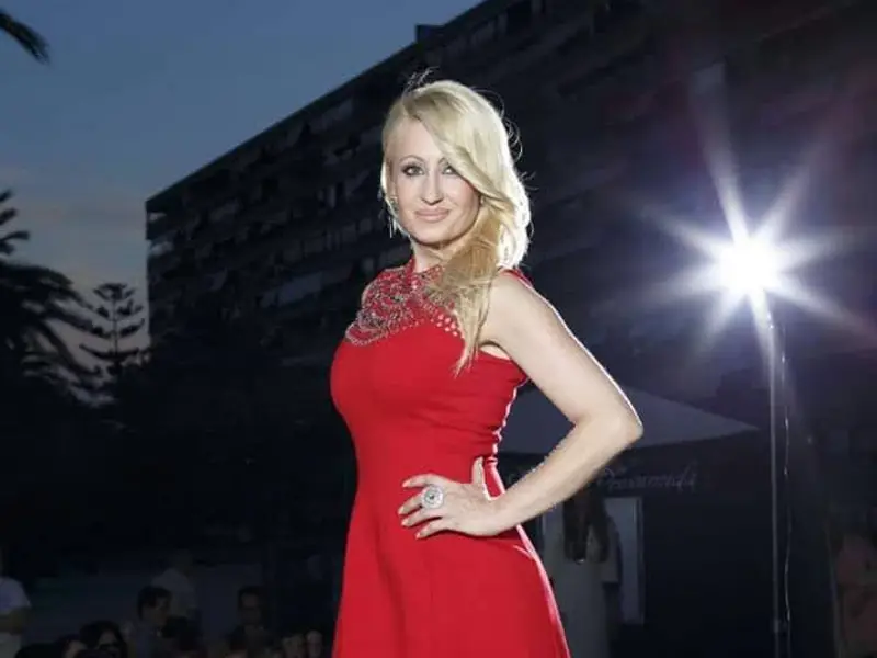 Myriam del Pozo posando en una escalera dorada con vestido de gala negro